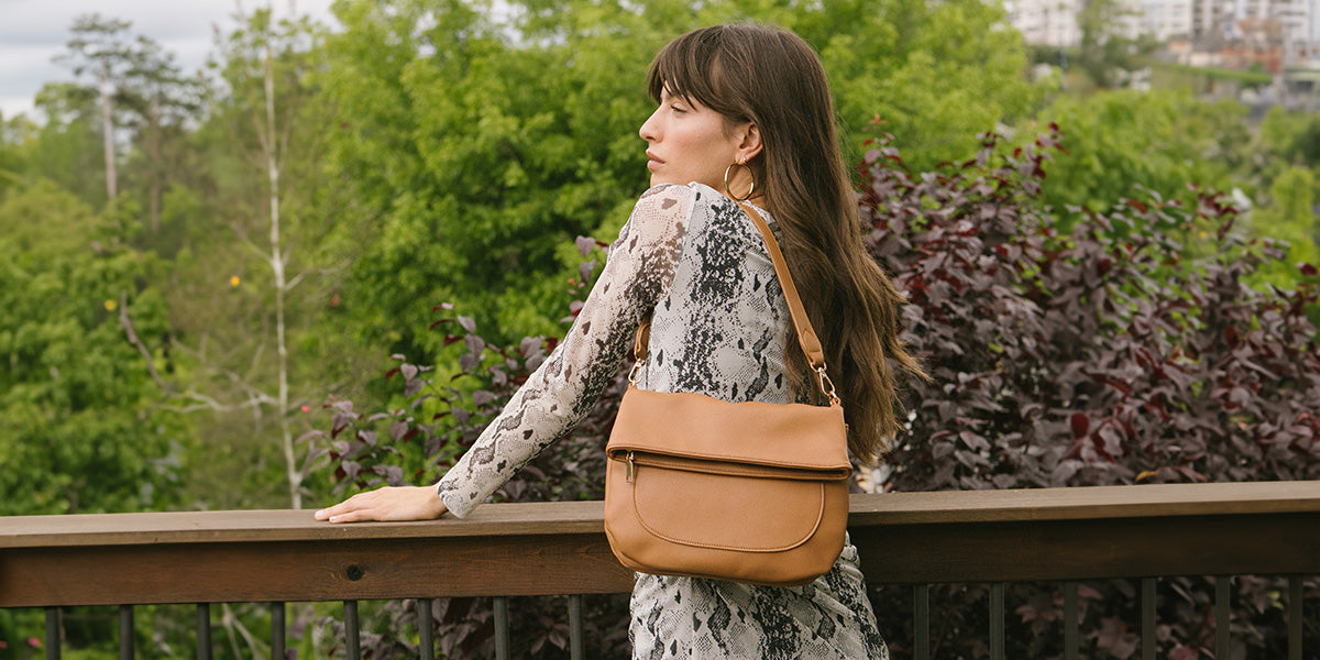 A woman with a leather purse admiring fall foliage