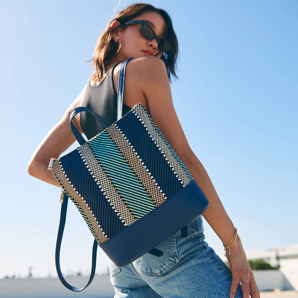 a woman wearing a blue embroidered backpack